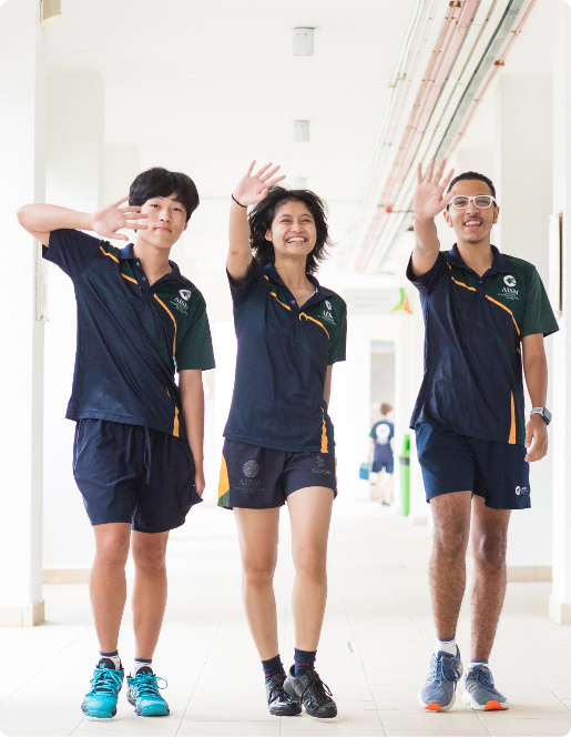 Three AISM students in school uniforms enthusiastically wave their hands, promoting the pre-university scholarship application.