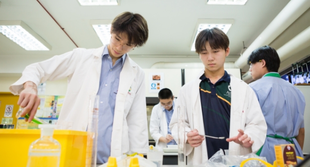 AISM students participating in co-curricular activities by putting on lab coats team up for a project.