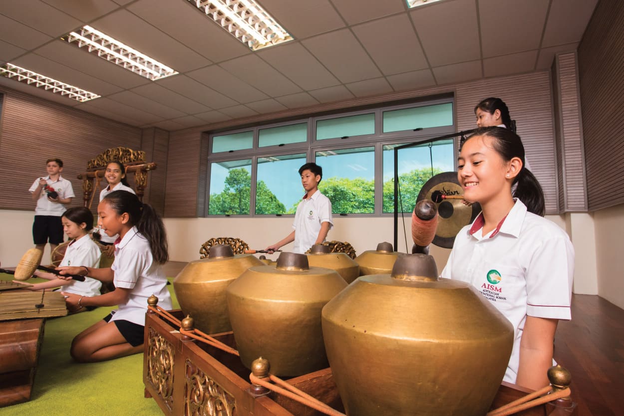 A music classroom scene of students playing the Gamelan instruments.